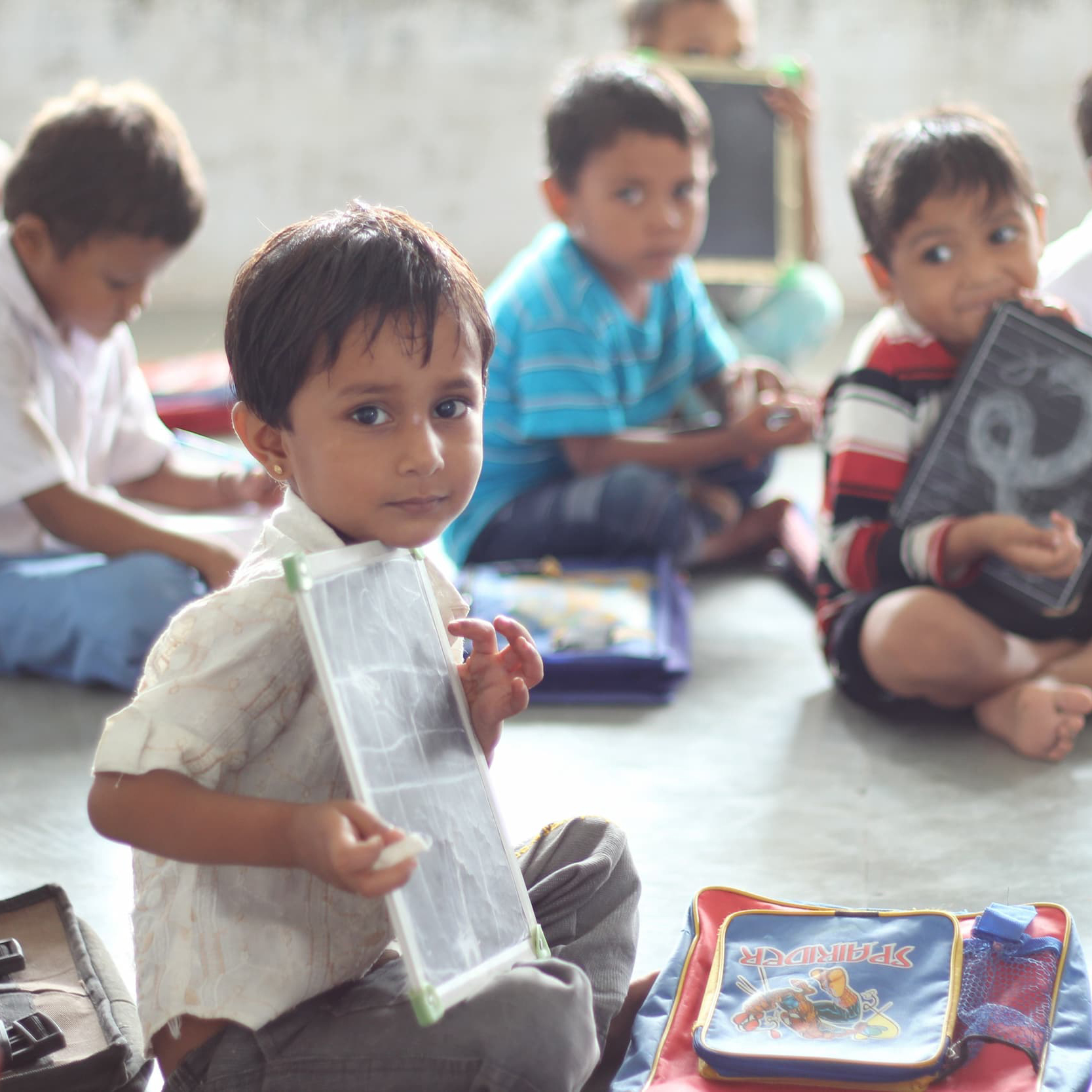 akshayapatra-foundation-india-child-chalkboard-floor-pixabay-square Children sit on the floor with writing tools. Photo by Akshayapatra Foundation, Pixabay.