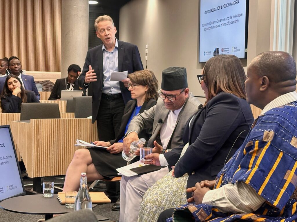 A man standing and speaking with seated panellists