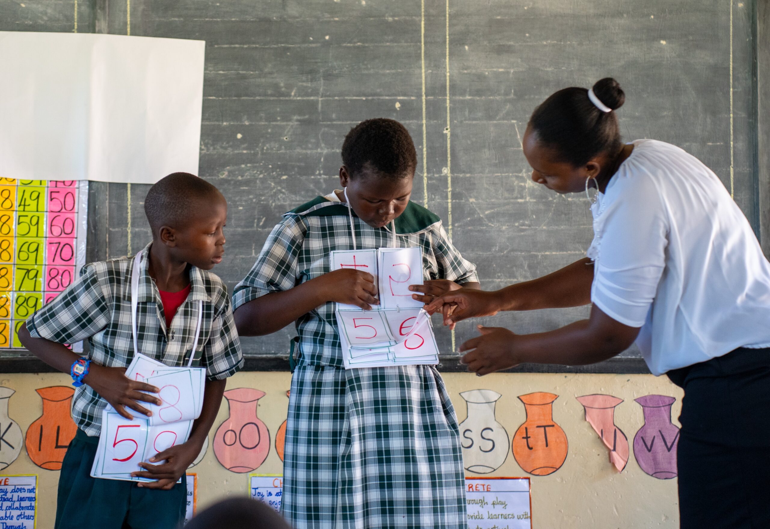 Teacher and two students at the front of the classroom