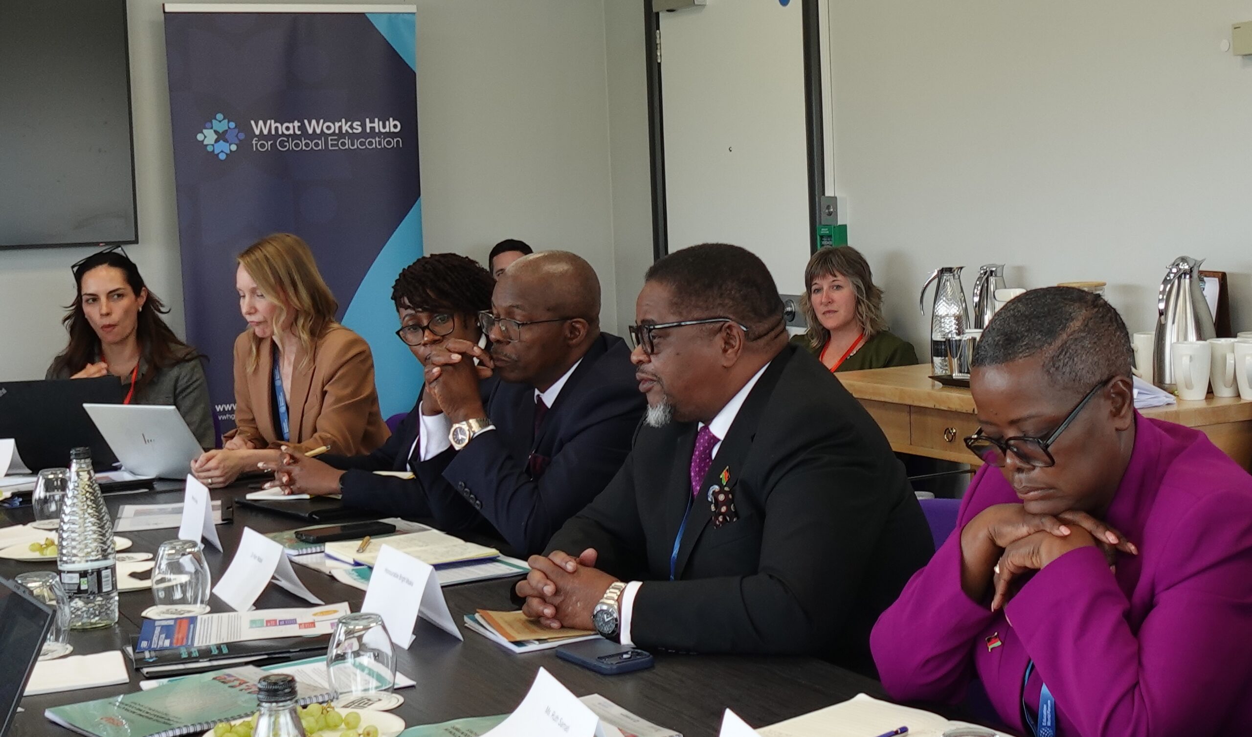 Government officials and education partners participate in a discussion in a room