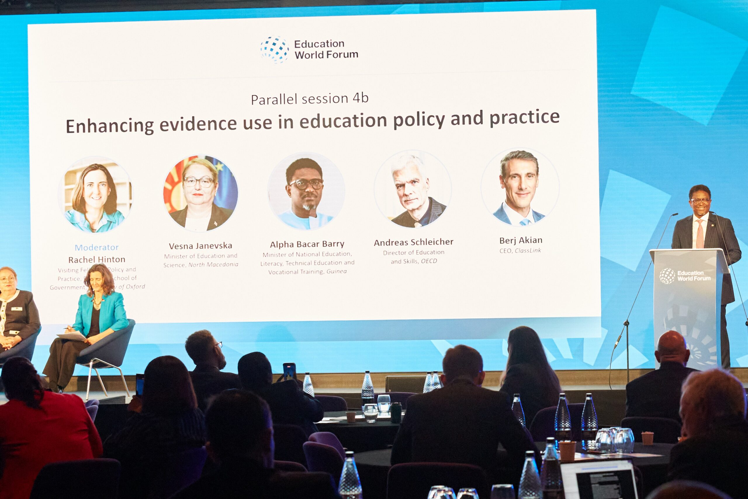 Panel session on enhancing evidence use in education policy and practice at the Education World Forum, with speakers on stage and an audience watching